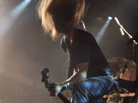 Damien Sisson headbanging while playing bass with Death Angel in Paris
